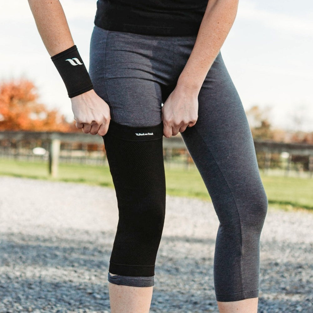 women pulling up a knee brace and wearing a wrist brace