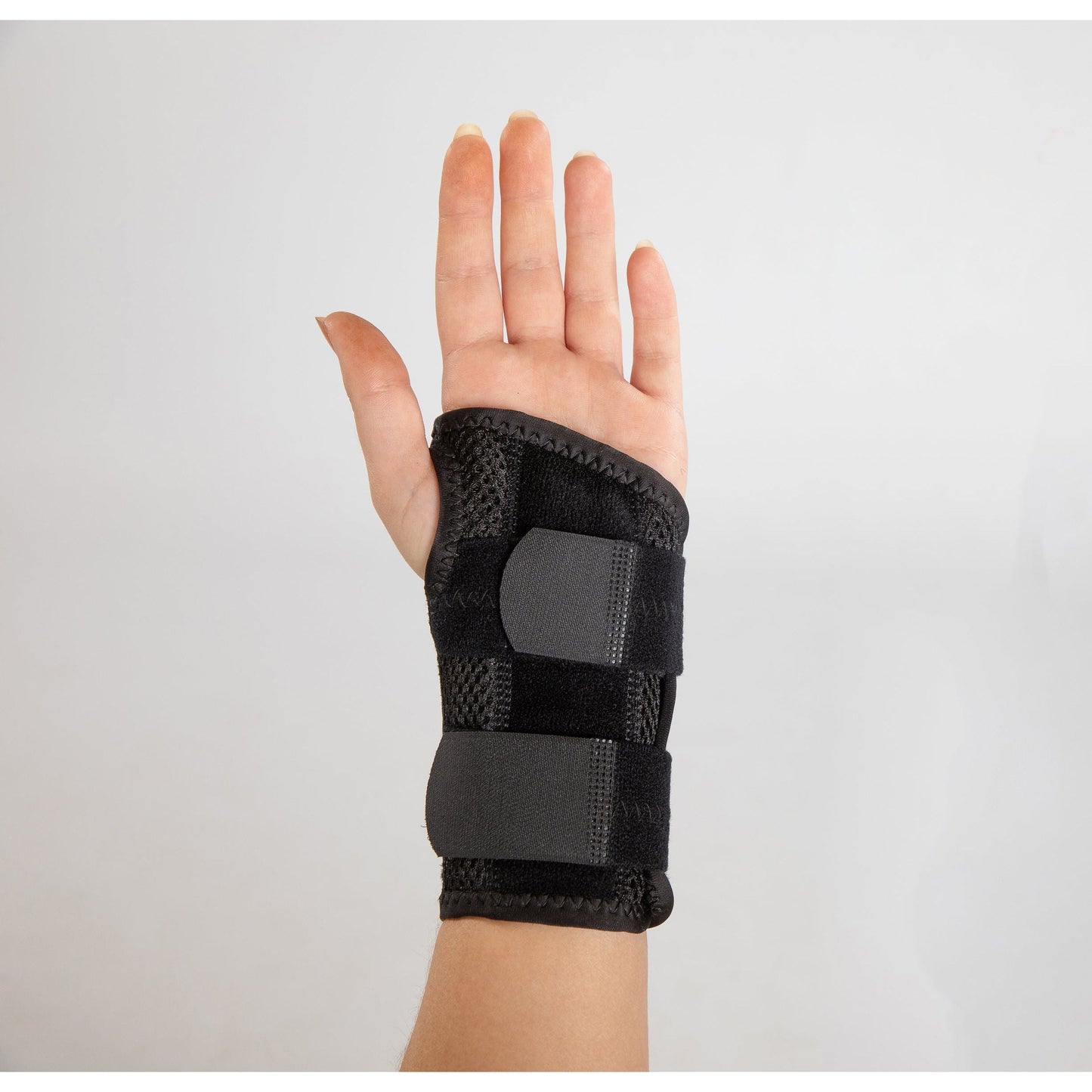 black splinted carpus wrist brace on hand (palm side up)