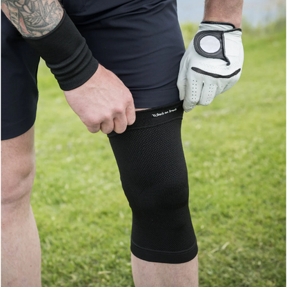 black knee brace with 4-way stretch being worn by a golfer