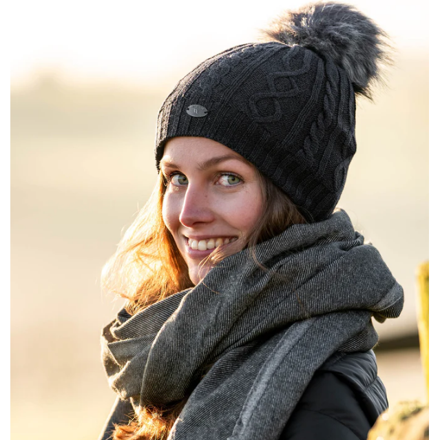 dark grey beanie with pom pom being worn by women